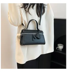 Detailansicht der schwarzen Saffiano-Handtasche mit silbernen Reißverschlüssen und Standfüßen