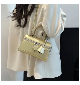 Tragebeispiel der goldenen Box-Tasche mit Metallstruktur und verstellbarem Schultergurt