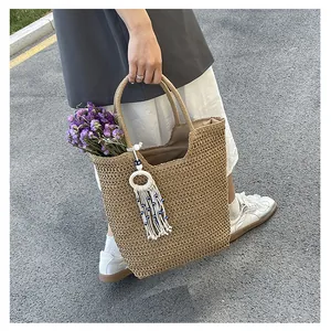 Detail of straw tote bag with evil eye tassel charm and lavender flowers for beach decor