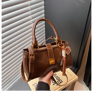 Detailed macro view of vintage brown leather handbag texture with a bear tassel charm