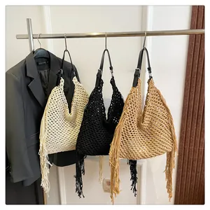 Detail view of woven mesh texture and long tassels on handmade beach tote bags