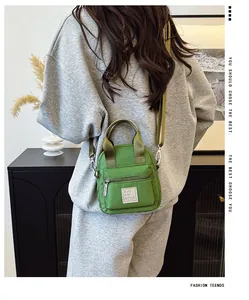 Grüne Nylon-Umhängetasche für Handys, Rückansicht am Modell zur Veranschaulichung
