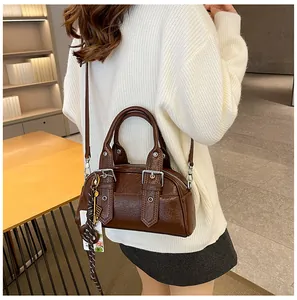Détail d'un sac Boston vintage marron foncé avec texture plissée et foulard décoratif
