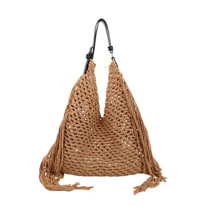 Handmade woven tote bag with fringe tassels and black leather shoulder strap on white background