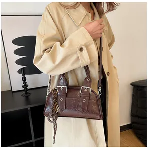 Détail d'un sac à bandoulière vintage marron foncé avec texture huilée brillante et boucle