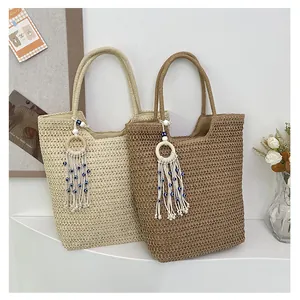 Close-up of woven straw tote bags with bohemian tassel charms and natural texture