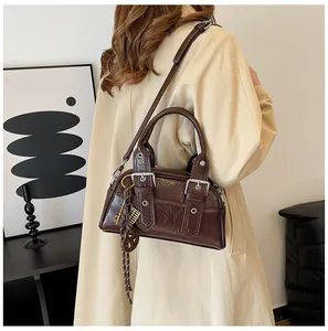 Détail du sac à bandoulière vintage marron foncé avec boucle métallique et lanière