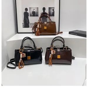 Close-up of minimalist glossy leather handbags in black and brown with metal locks