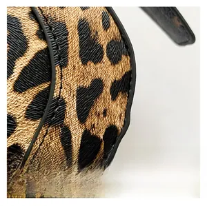 Close-up of leopard print crossbody bag showing textured synthetic leather and black edge paint