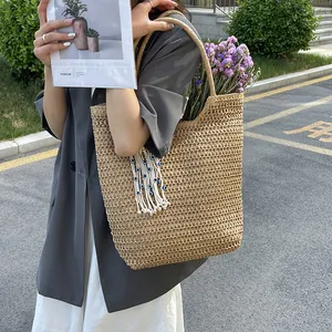 Large woven shoulder bag with evil eye tassel charm and dried flowers for summer