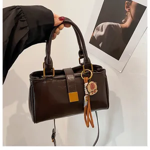 Detailed macro of dark brown matte faux leather handbag with golden square buckle