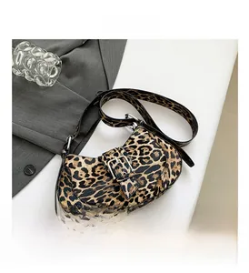 Detail of leopard print crossbody bag with silver buckle and adjustable strap