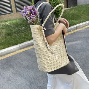 Large beige woven straw tote bag with tassels for beach or commuting commute style