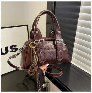 Détails du sac à main en cuir marron foncé avec boucles métalliques et textures