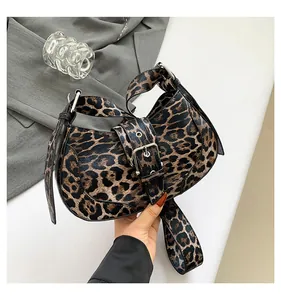 Detail of vintage leopard print crescent bag with large silver metal buckle strap