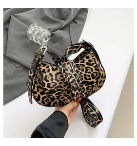 Detail of leopard print saddle bag with metal buckle and wide shoulder strap