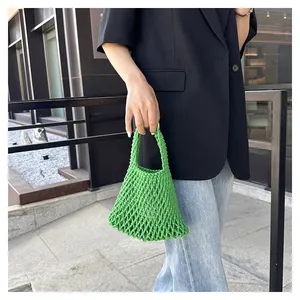 Detail of emerald green handmade woven mesh tote bag with artistic hollow-out texture