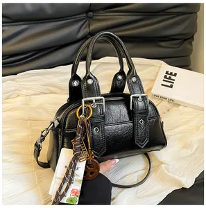 Détail du sac à main rétro noir texturé avec boucles argentées et pendentif boulier