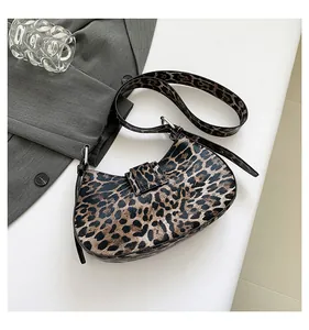 Detailed close-up of a leopard print hobo bag with adjustable strap and silver metal buckle
