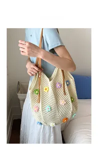 Detail of hand-crocheted cream tote with 3D colorful floral patterns and brown leather strap