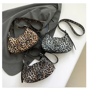 Three leopard print crossbody bags in brown, blue, and dark tones with metal buckles