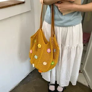 Chic yellow hand-knitted crossbody bag featuring 3D floral accents and leather straps
