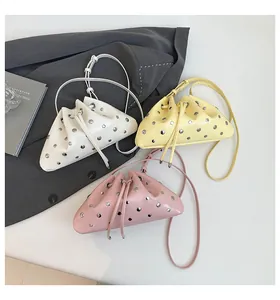 Close-up of bucket bags with metal rivets in white, yellow, and pink colors