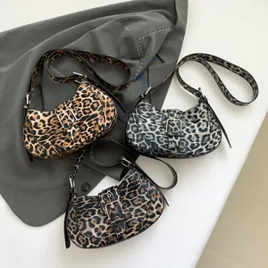Three leopard print crossbody bags in gold, grey, and coffee brown on a stylish blazer