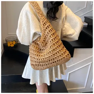 Close-up of hollowed-out straw woven hobo bag showing large-hole craftsmanship on shoulder