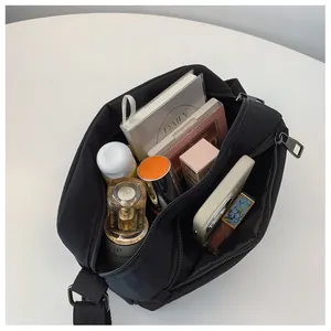 Internal compartments of the black nylon crossbody bag showing spacious storage for daily items