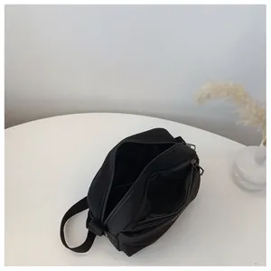 Top view of compact black nylon crossbody bag interior showing multiple storage compartments