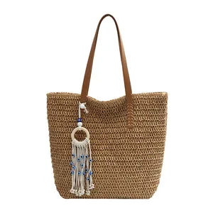Handgewebte Stroh-Tote-Bag mit braunen Riemen und böhmischem Evil Eye Quastenanhänger