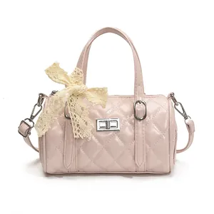 Sac cylindrique rose matelassé avec fermoir argenté et détail de nœud en dentelle