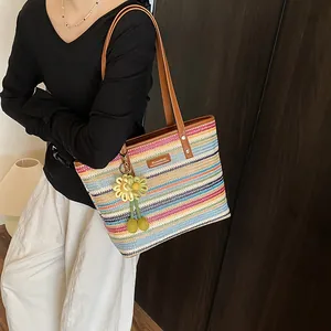 Rainbow striped woven beach tote bag with brown leather trim and sunflower charm accessory