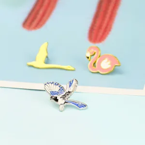 Detaillierte Makroansicht bunter Emaille-Vogelbrosche-Set mit Flamingo und Schwan
