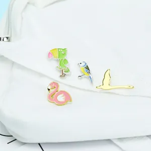 Detail von bunten Cartoon-Vogel-Emaille-Pins an einem weißen Canvas-Taschengurt