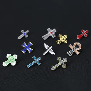 Vue macro de broches en croix émaillées colorées avec des ailes et motifs religieux