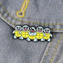 Détail de cinq épingles en émail Carapuce sur tissu denim bleu montrant des personnages