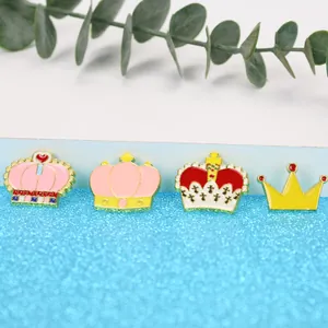 Lot de quatre pins en émail en forme de couronne avec détails de cœur et croix sur fond bleu