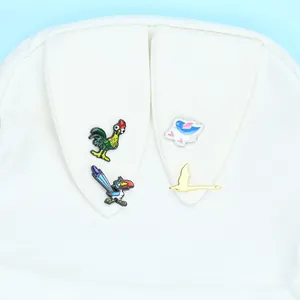 Detailaufnahme von Cartoon-Vogel-Emaille-Anstecknadeln auf einer weißen Segeltuchtasche