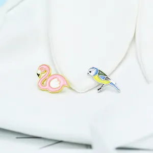 Süße Emaille-Vogel-Broschen mit rosa Flamingo und Blaumeise auf weißem Stoff