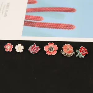 Detaillierte Nahaufnahme von sechs Emaille-Blumenbroschen mit Goldrand und bunten Blüten
