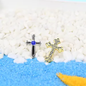 Détail de broches croix en métal vintage avec émail bleu et détails d'ailes ciselés