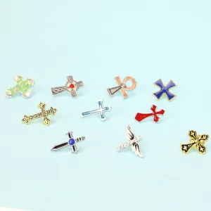 Détails de broches religieuses en forme de croix avec émail et motifs d'ailes en métal