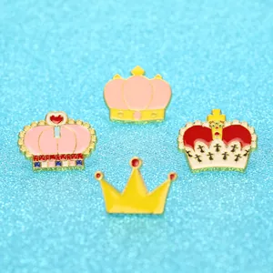 Lot de quatre broches couronnes en émail coloré avec détails dorés sur fond bleu