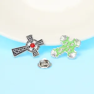 Détail de broches en croix avec nœud celtique et cristal rouge sur fond bleu clair