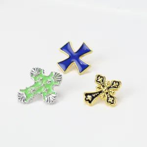 Trois broches croix vintage en métal avec finitions émaillées et gravures sophistiquées