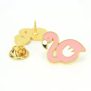 Detalle del broche de flamenco rosa esmaltado con bordes dorados y cierre de mariposa