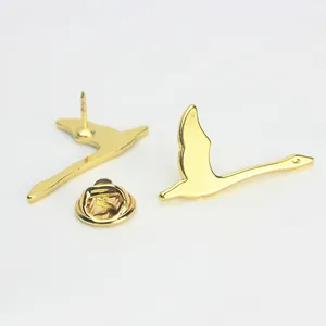 Detalle de broches de aves en metal dorado con acabado pulido y cierre de mariposa