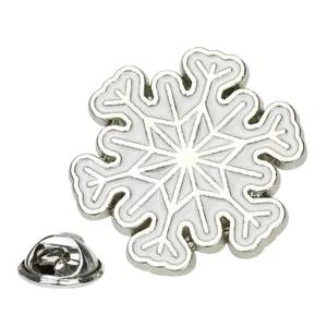 Broche flocon de neige argentée avec émail blanc et fermoir papillon en métal